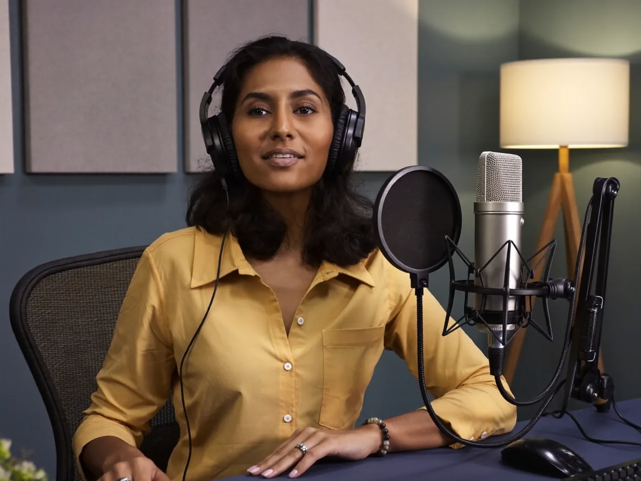 A woman recording a voice-over at a studio microphone