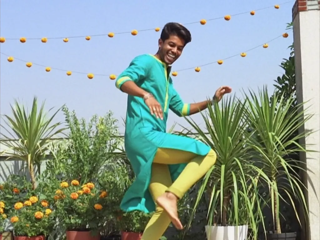 A young man dancing on a sunny rooftop